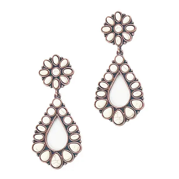 Dust & Petals Earrings featuring teardrop-shaped dangles with cream-colored stones arranged in a floral pattern, set in antique copper frames, displayed against a white background.