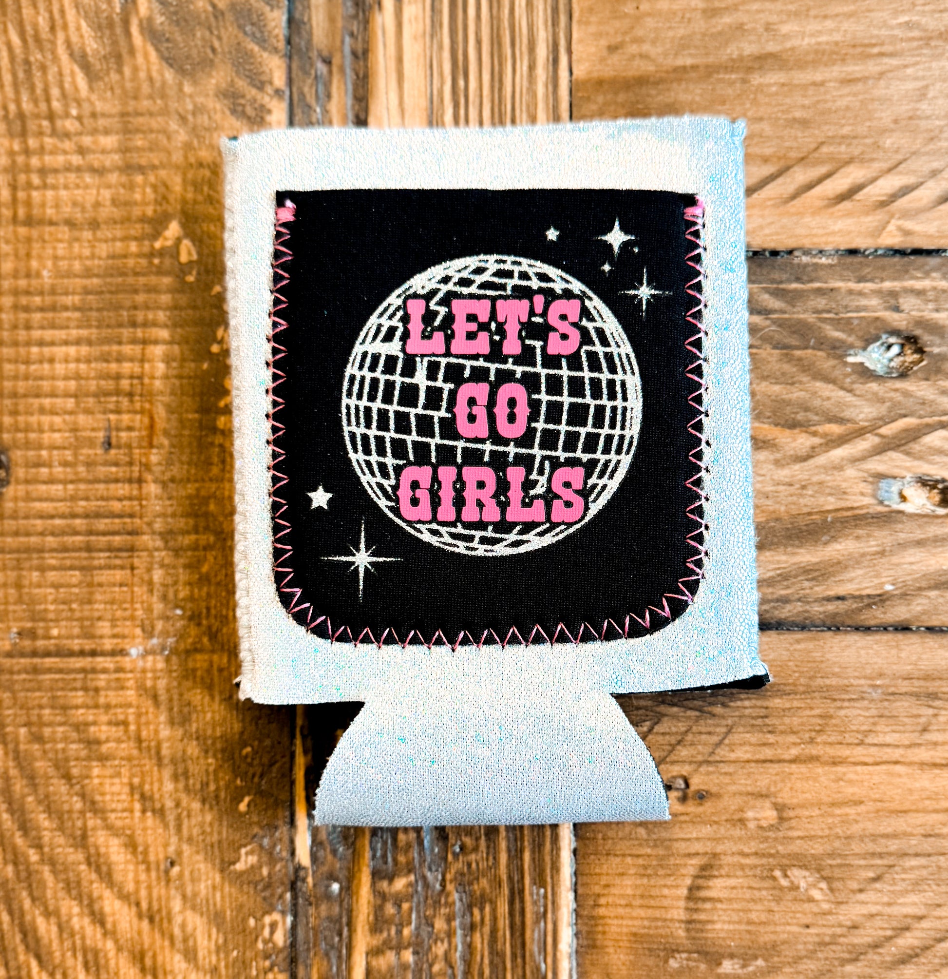 Glittery light blue sequin can cooler featuring a black patch with a disco ball design and pink text that says âLETâS GO GIRLS.â