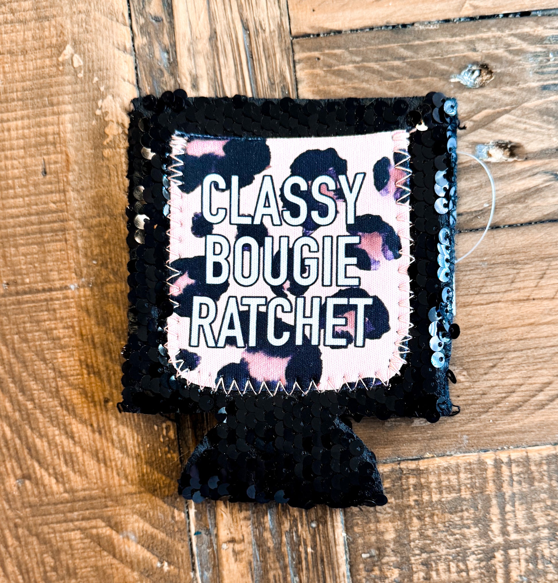 Black sequin can cooler with a pink and black leopard print patch that says âCLASSY BOUGIE RATCHETâ in all caps.