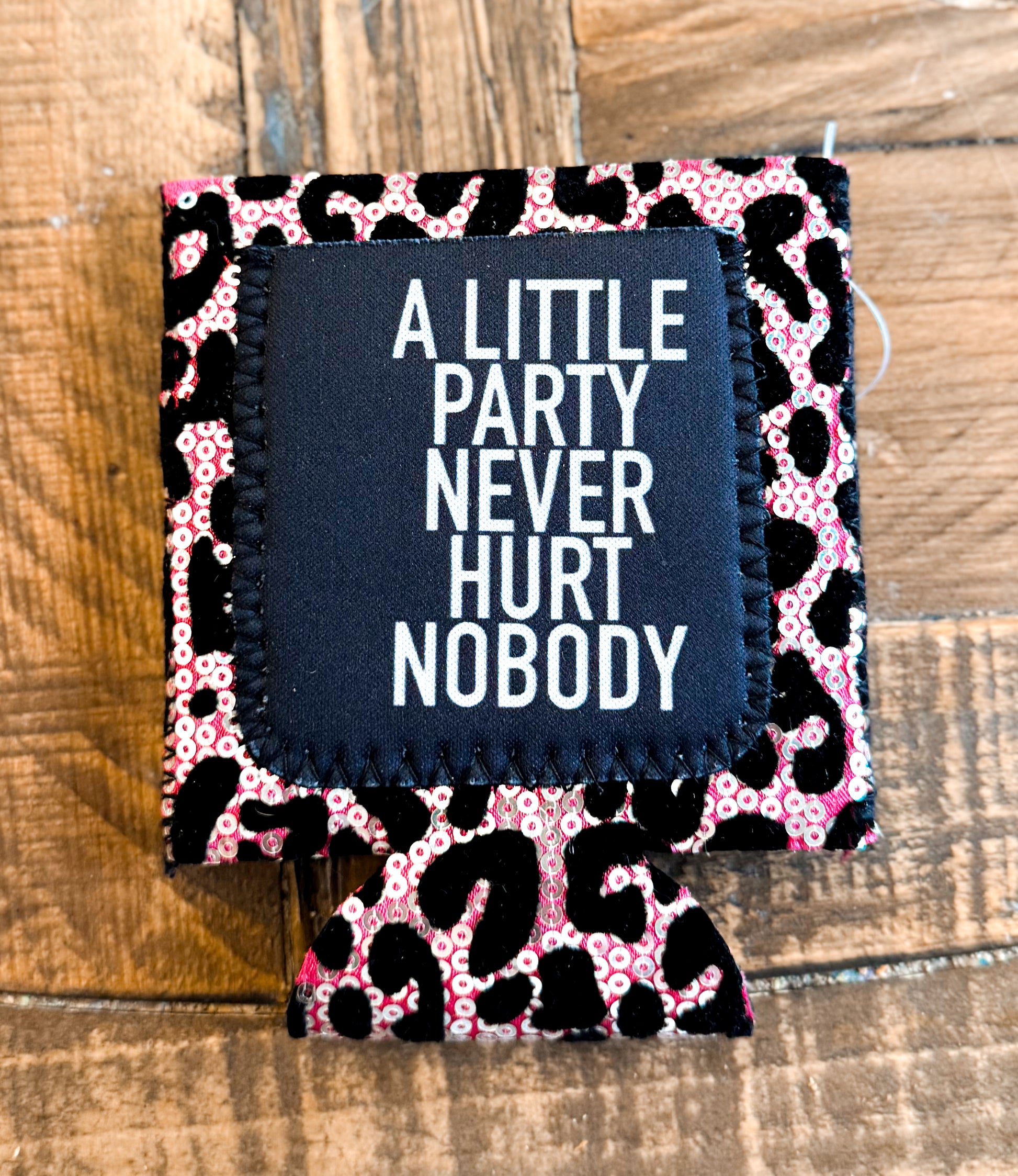 Pink leopard print sequin can cooler with a black patch that reads âA LITTLE PARTY NEVER HURT NOBODYâ in bold white text.