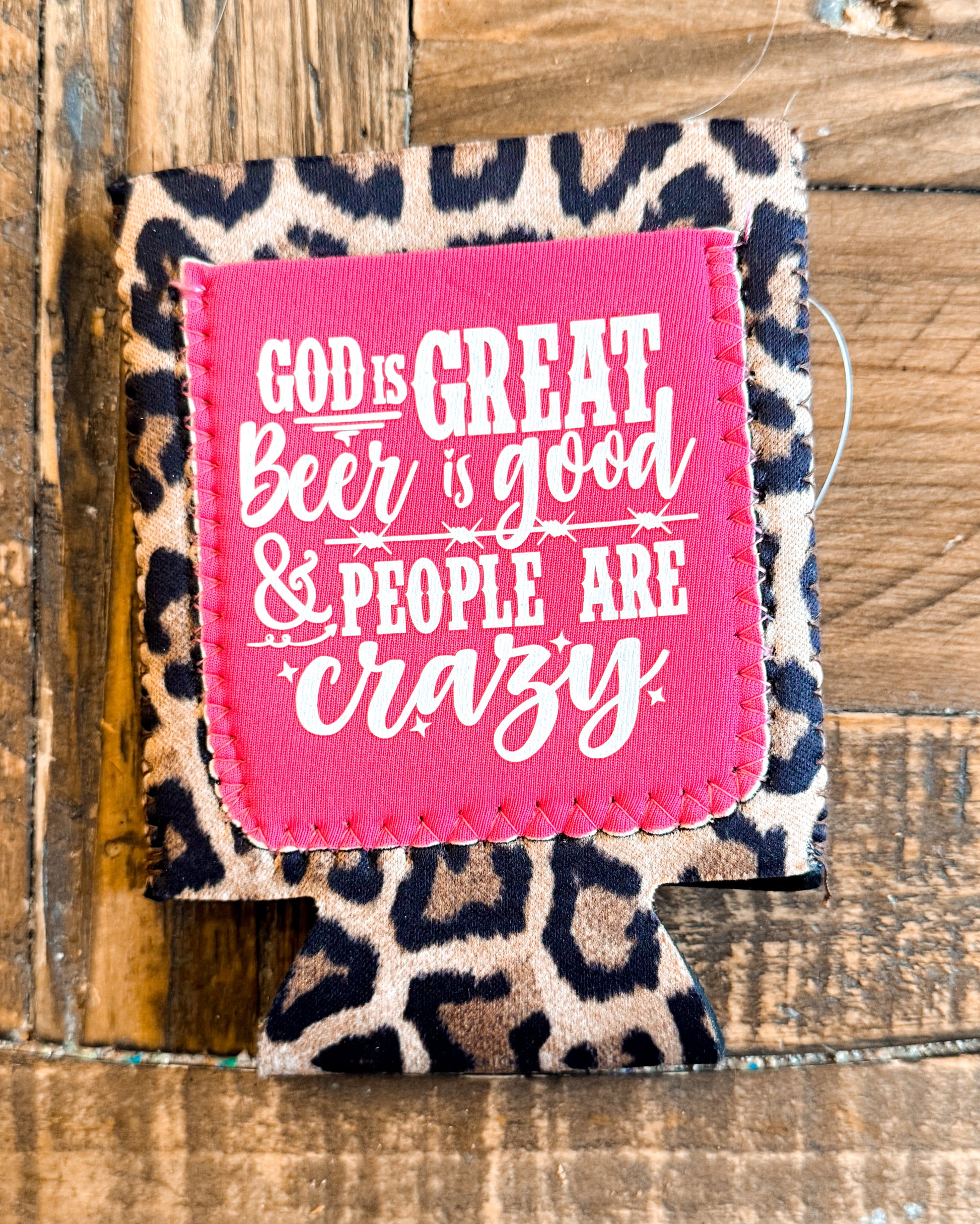 Leopard print fabric can cooler with a hot pink patch that says âGOD IS GREAT, BEER IS GOOD & PEOPLE ARE CRAZYâ in fun white lettering.