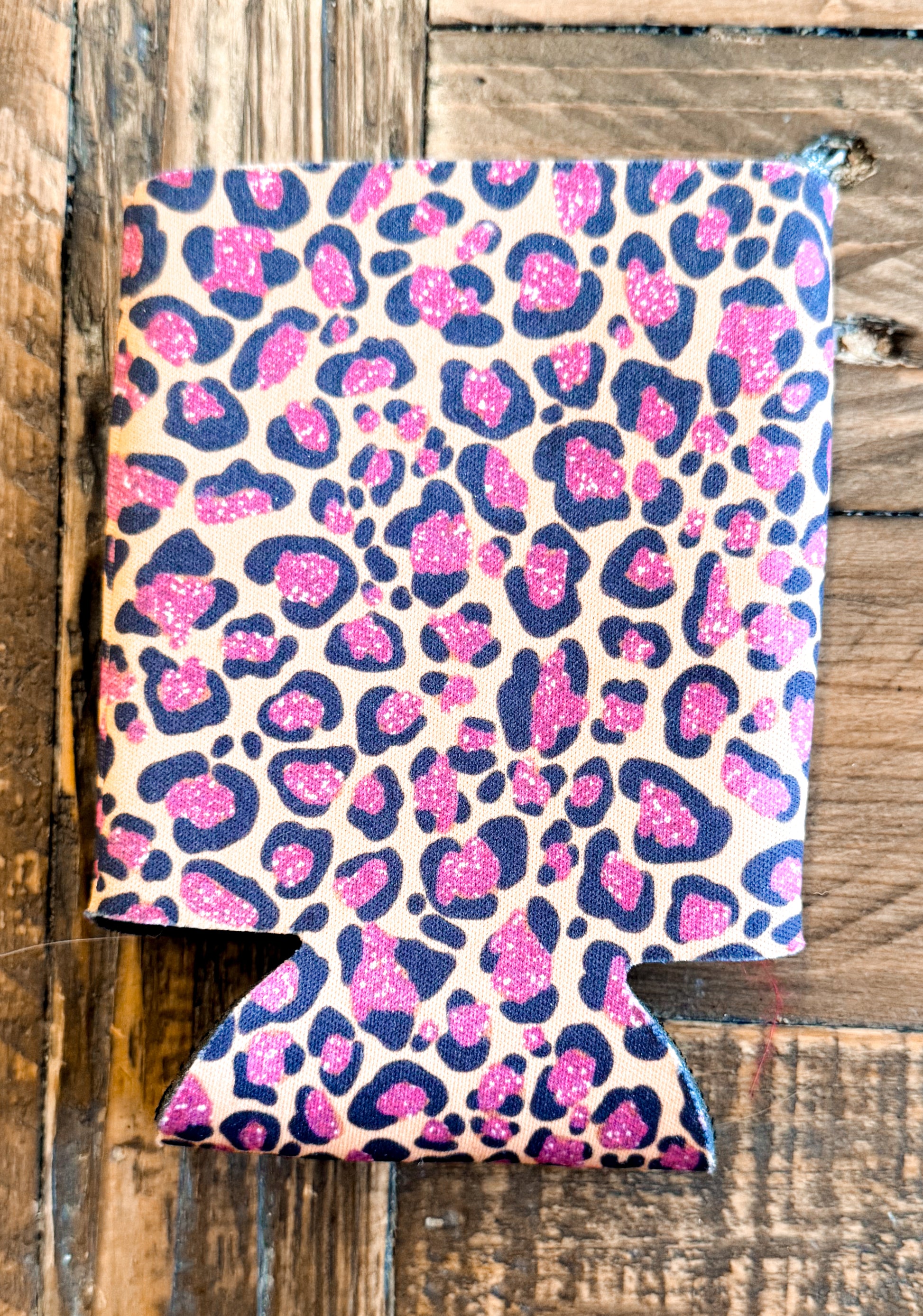 Can cooler with a beige background and bold black leopard spots filled with sparkly hot pink accents — fierce and fabulous.