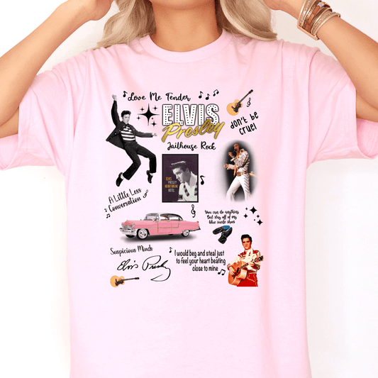 Woman wearing a light pink T-shirt featuring a colorful Elvis Presley collage design. The shirt includes iconic images of Elvis performing, a pink Cadillac, musical notes, guitars, and titles of famous songs like “Jailhouse Rock,” “Love Me Tender,” and “A Little Less Conversation.” The design also features Elvis’s name in bold lettering and scattered lyrics in various fonts. The overall aesthetic is playful and nostalgic.